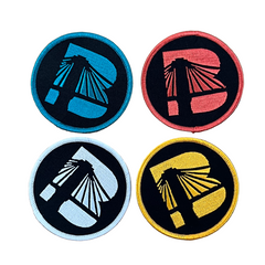 Four round stickers with different colored designs on a wooden surface