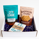 Three snack packages from City League, Brooklyn Brittle, and a box with 'Brooklyn' branding on a white background.