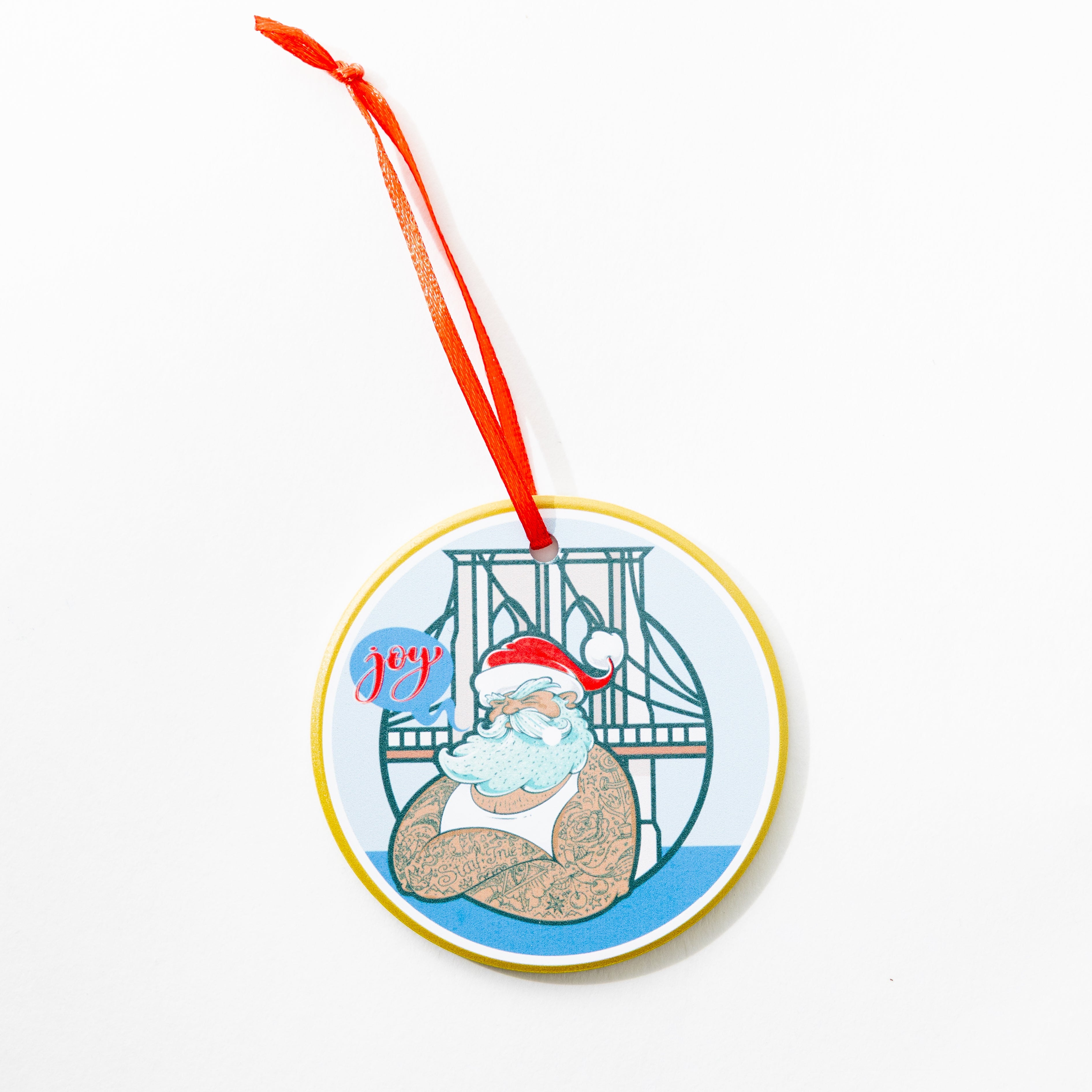 Stanley Lambert Artist Ceramic Decorative ornament with a illustrated tattooed Santa with blue speech bubble saying Joy with Brooklyn Bridge in background