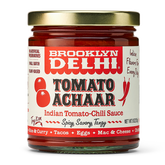 Jar of Brooklyn Delhi Tomato Achaar sauce with a gold lid on a white background