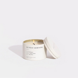 Candle in a white container with 'Sunday Morning' text on a light gray background