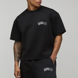 Person wearing a black 'Brooklyn' t-shirt and shorts on a gray background