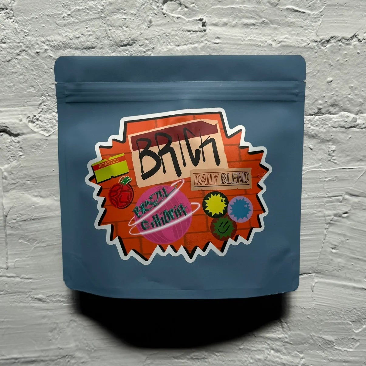 Blue packaging with colorful label on a textured gray background