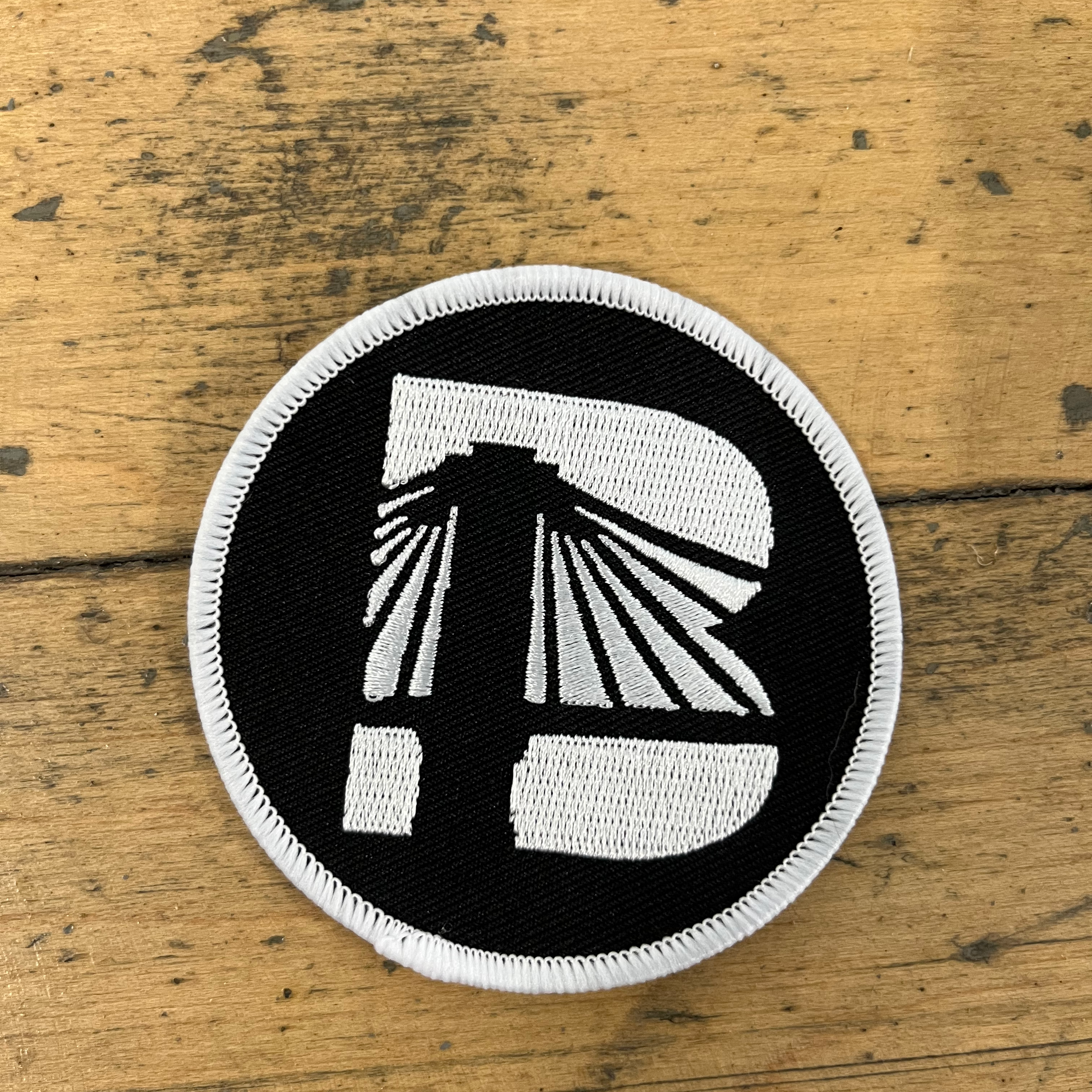 Black and white patch with a design on a wooden surface