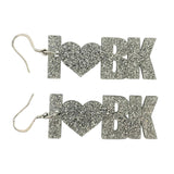 Silver glittery 'I ❤️ BK' earrings on a white background
