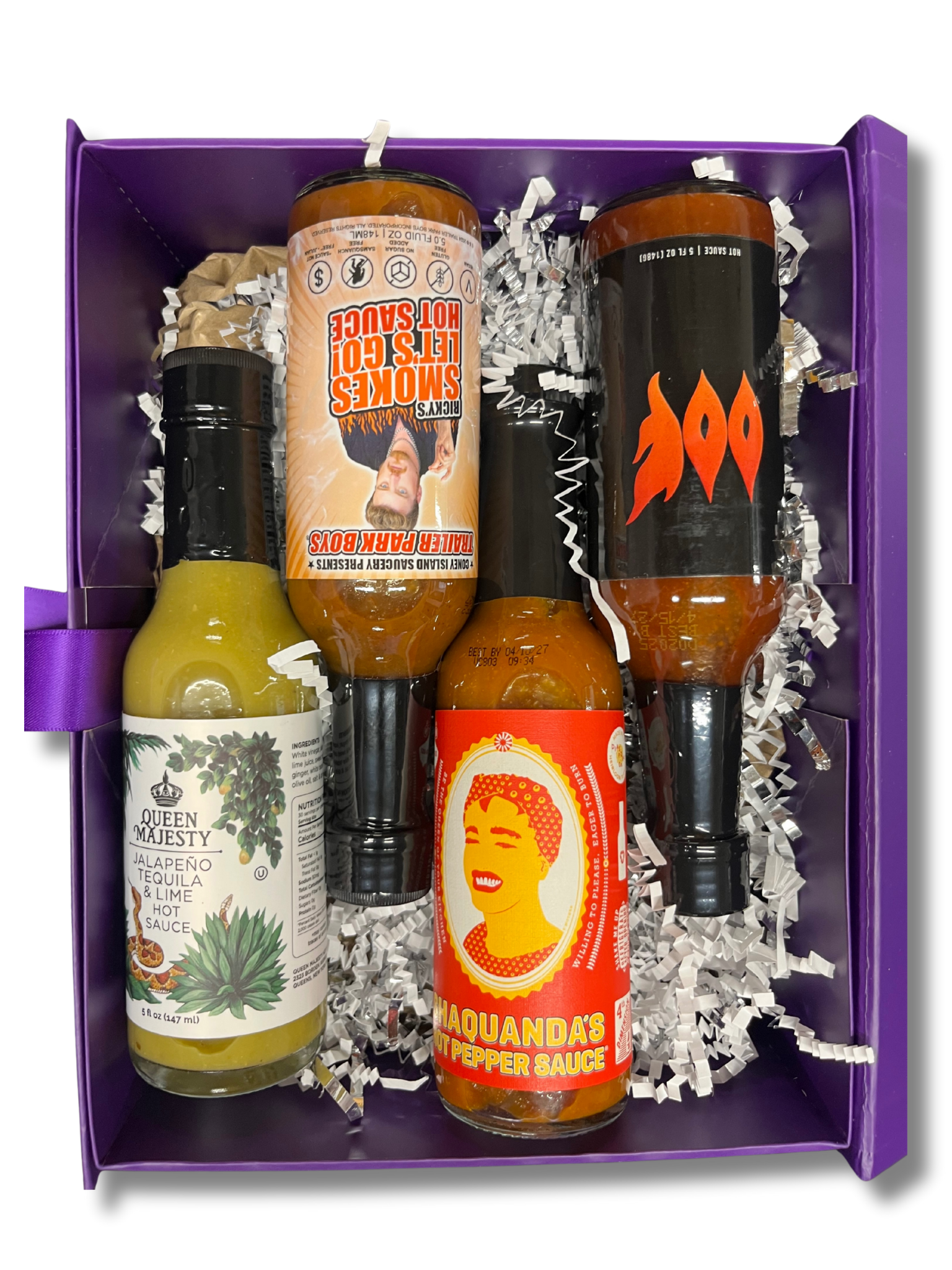 Photo of 4 different bottles of hot sauce in a purple gift box