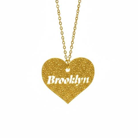 Gold heart-shaped necklace with 'Brooklyn' engraving on a white background